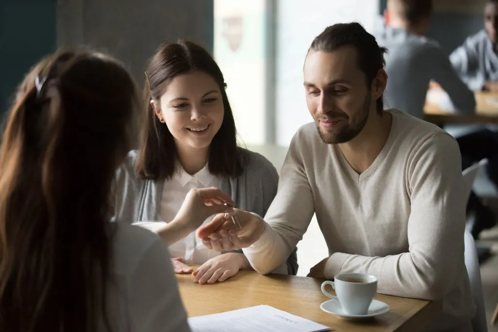 happy-millennial-couple-getting-keys-to-new-house-from-realtor-min.jpg покупка